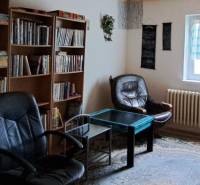 Living room in a family house with a library, armchairs, and a table.