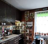 A kitchen in a family house with hanging shelves, kitchen tools, and decorative glasses.