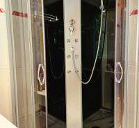 Shower enclosure with glass doors in a 2-room apartment.
