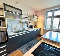 Kitchen in a 2-room apartment with a kitchen unit, table, and cooktop.