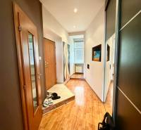 A hallway with a wooden floor and a wardrobe in a 2-room apartment, decorations on the walls.