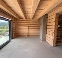 Interior of a wooden cabin with a large window and a staircase.