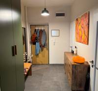 A hallway in a 4-room apartment with dark tiles, wooden furniture, and decorations.