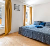 A bright bedroom with a double bed and large windows in a 2-room apartment.