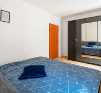 Bedroom in a 2-room apartment with a large wardrobe and blue bedding.