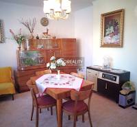 Living room of a family house with a dining table, armchair, and furniture.
