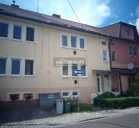 A family house in Nováky with a garage and floral decorations on the facade.