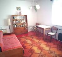 Living room in a family house with a sofa set and a bookshelf.