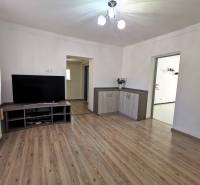 Living room in a family house with wooden flooring and a television on a low cabinet.