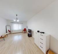 Interior of a family house with wooden flooring, furniture, and a large window.