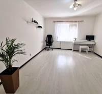 A spacious bright room with a desk and a black chair in a family house.