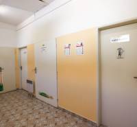 Hallway with doors in commercial premises, light walls and tiled floor.