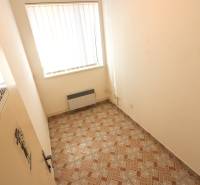 Small room with tiles, radiator, and sign 