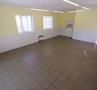 Commercial premises with tiles, light walls, and windows, suitable for business.