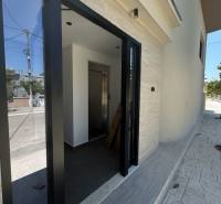 The entrance to the Recreational Apartment in Ksamil has glass doors and a bright interior.