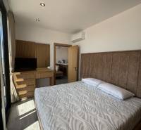 Bedroom in a holiday apartment with a double bed, built-in wardrobe, and air conditioning.