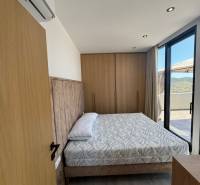 Bedroom in a holiday apartment with a comfortable bed, tasteful furnishings, and a balcony.