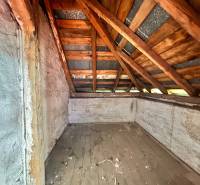 The attic of a family house with a wooden roof truss and old wooden floor cladding.
