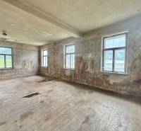 Abandoned room in a family house with damaged floors and walls.