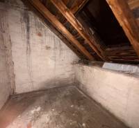 Attic in a family house with an old wooden floor and a slanted ceiling.