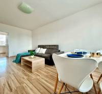 Living room in a 4-room apartment with a sofa and a dining table with chairs.