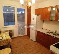 Kitchen and space in a 2-room apartment with a wooden kitchen unit and table.