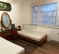 Two beds, a mirror, paintings, and a carpet in a room in a two-room apartment.