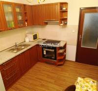 A kitchen with wooden cabinets and appliances in a 2-room apartment, optimal for cooking.
