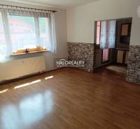 Sunny living room with laminate flooring and stone cladding in a 3-room apartment.