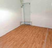 An empty room in a 3-room apartment with laminate flooring and white walls.