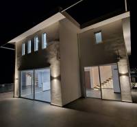 The exterior of a holiday apartment in Sarandë illuminated by night light.