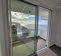 Glass sliding doors with a view of the sea in a holiday apartment near Sarandë.