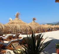Beach loungers and straw umbrellas in a holiday apartment near Sarandë.
