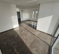 Interior of a vacation apartment with large windows and glossy tiles.