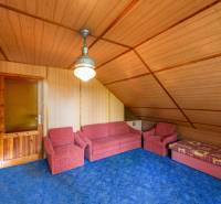 Wooden interior of a cabin with a sofa set and a blue carpet.