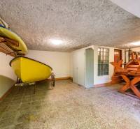Storage space in a cabin with a boat and a wooden table in the corner of the room.