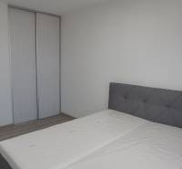 Bedroom with a double bed and a wardrobe in a two-room apartment.