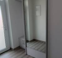 The entrance hall of a 2-room apartment with white doors and a built-in wardrobe.