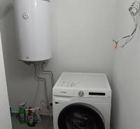 Laundry room in a 2-room apartment with a washing machine and a boiler.