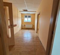 Hallway inside a building with wooden flooring and doors.