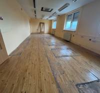 Space for rent in a building with wooden flooring, offered by a real estate agency.