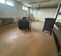 Interior of a room with shelves and windows, with evident wear on the floor and walls.