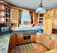 A kitchen in a 3-room apartment with built-in cabinets and a stove, dominated by wooden elements.