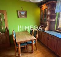 A kitchen interior in a 3-room apartment with wooden furniture and a green wall.