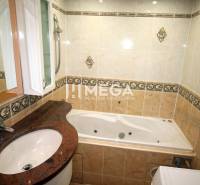 A bathroom in a 3-room apartment with a bathtub and a sink, decorated with tiles.