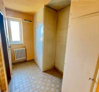 A narrow hallway with a radiator and built-in wardrobes in a 2-room apartment.