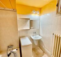 Bathroom with a bathtub, toilet, and washing machine in a 2-room apartment.