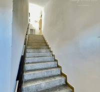 A staircase leading to the upper floor within a 2-room apartment.