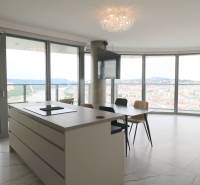 A kitchen with an island, a dining table, and a panoramic view in a 3-room apartment.