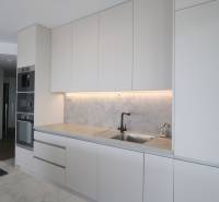 A kitchen in a 3-room apartment with white cabinets and built-in appliances.
